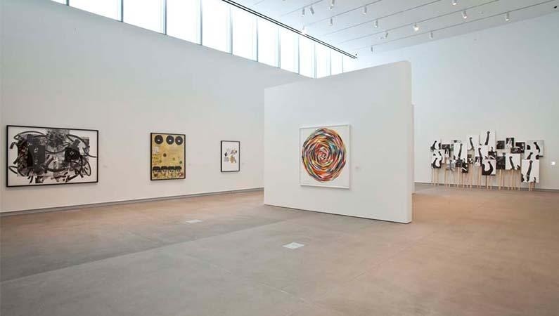 Installation view of several prints in an open, white-walled gallery space.