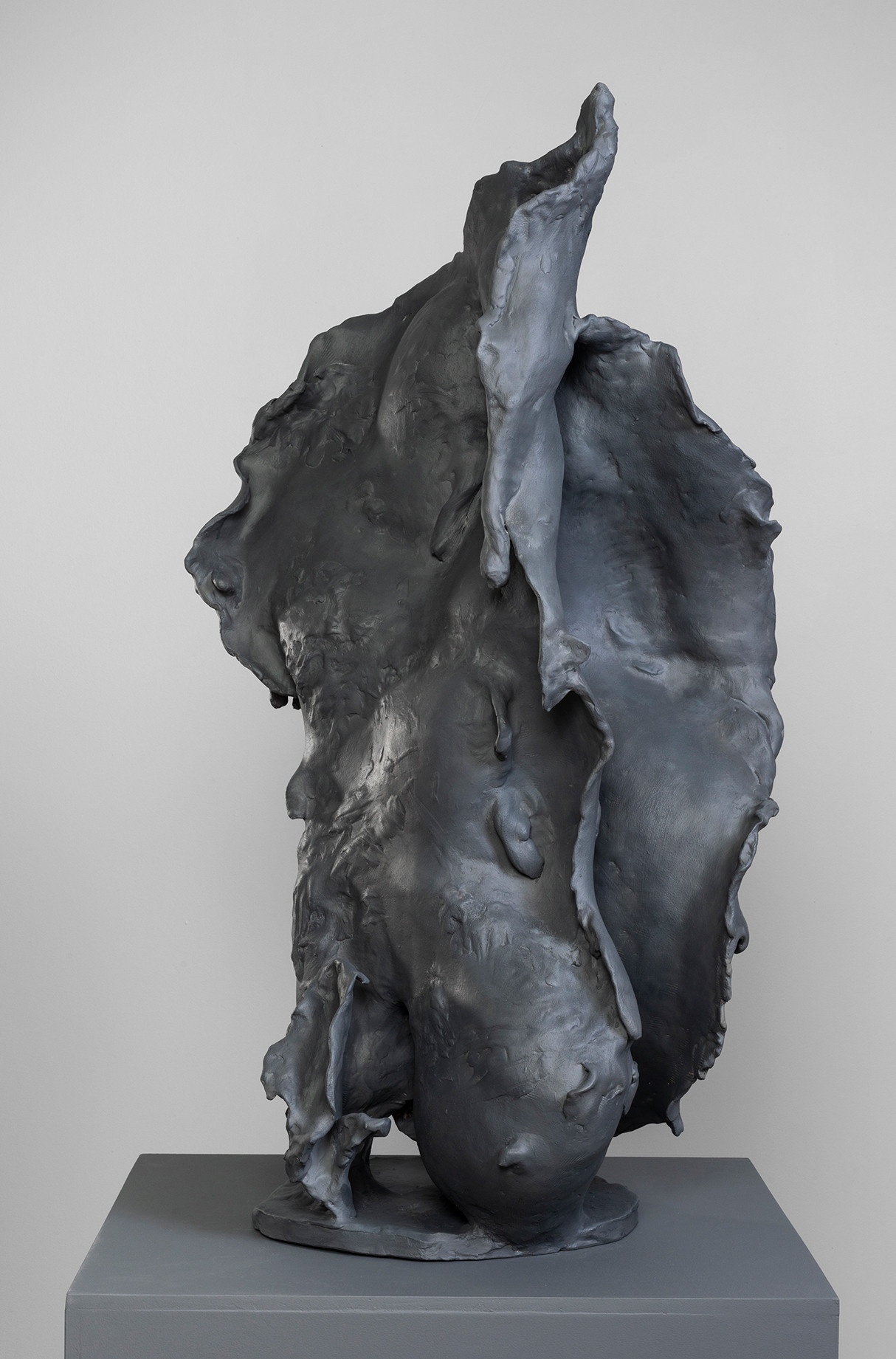 Ceramic sculpture, painted dark gray, with an uneven surface.