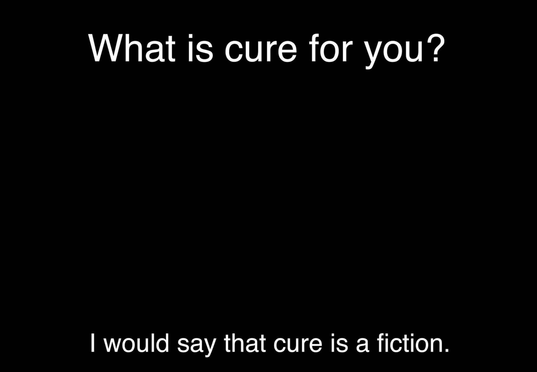 A video still from “Perspective” comprised of white text on a black background. At the top of the still is the question, “What is cure for you?” At the bottom of the still is the response, “I would say that cure is a fiction.”