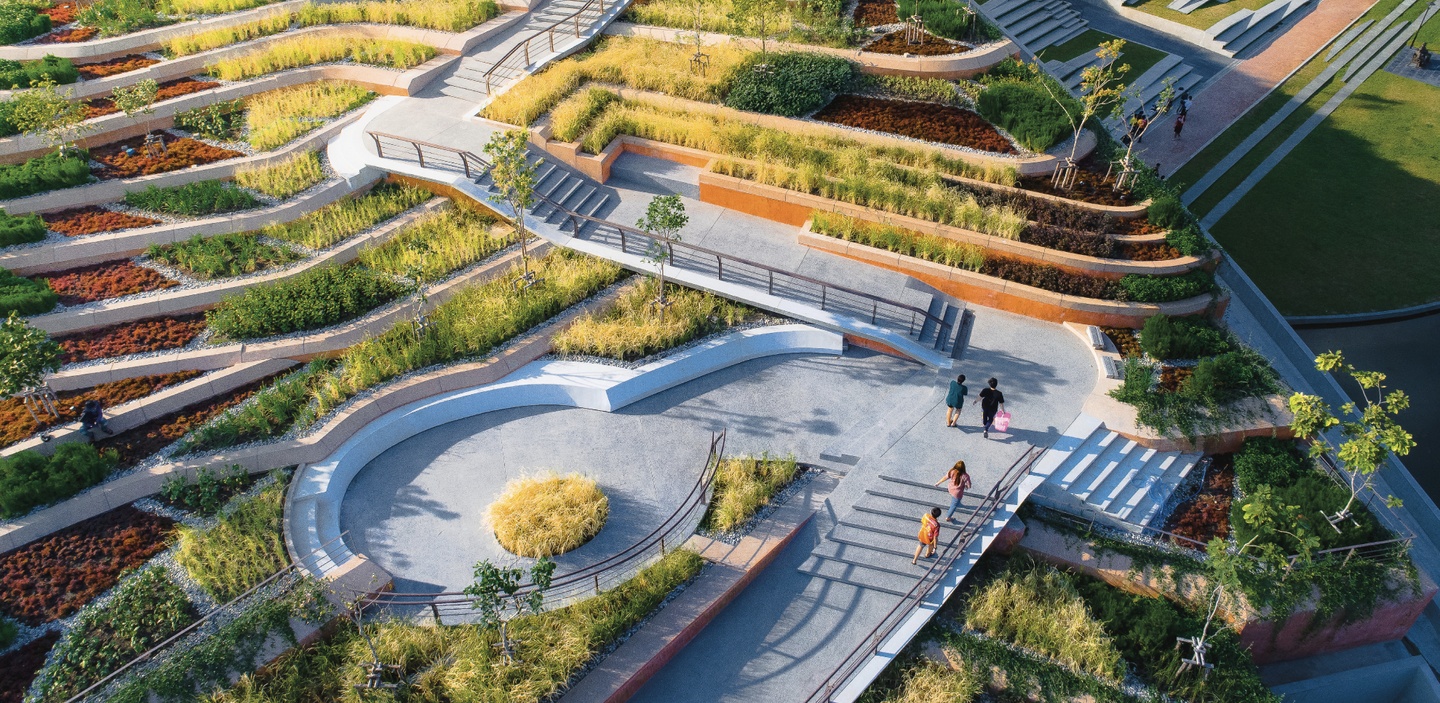 Overhead view of Thammasat University Urban Rooftop Farm, featuring numerous levels, with concrete or stone walkways and stairs in the midst of numerous tiers of plantings.