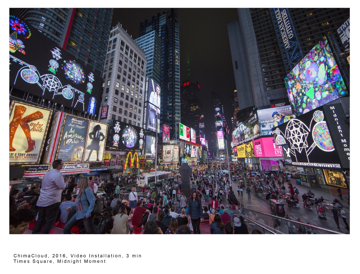 Colorful, glowing screens flank billboards and Broadway posters along a city skyline in New York's Times Square at night.