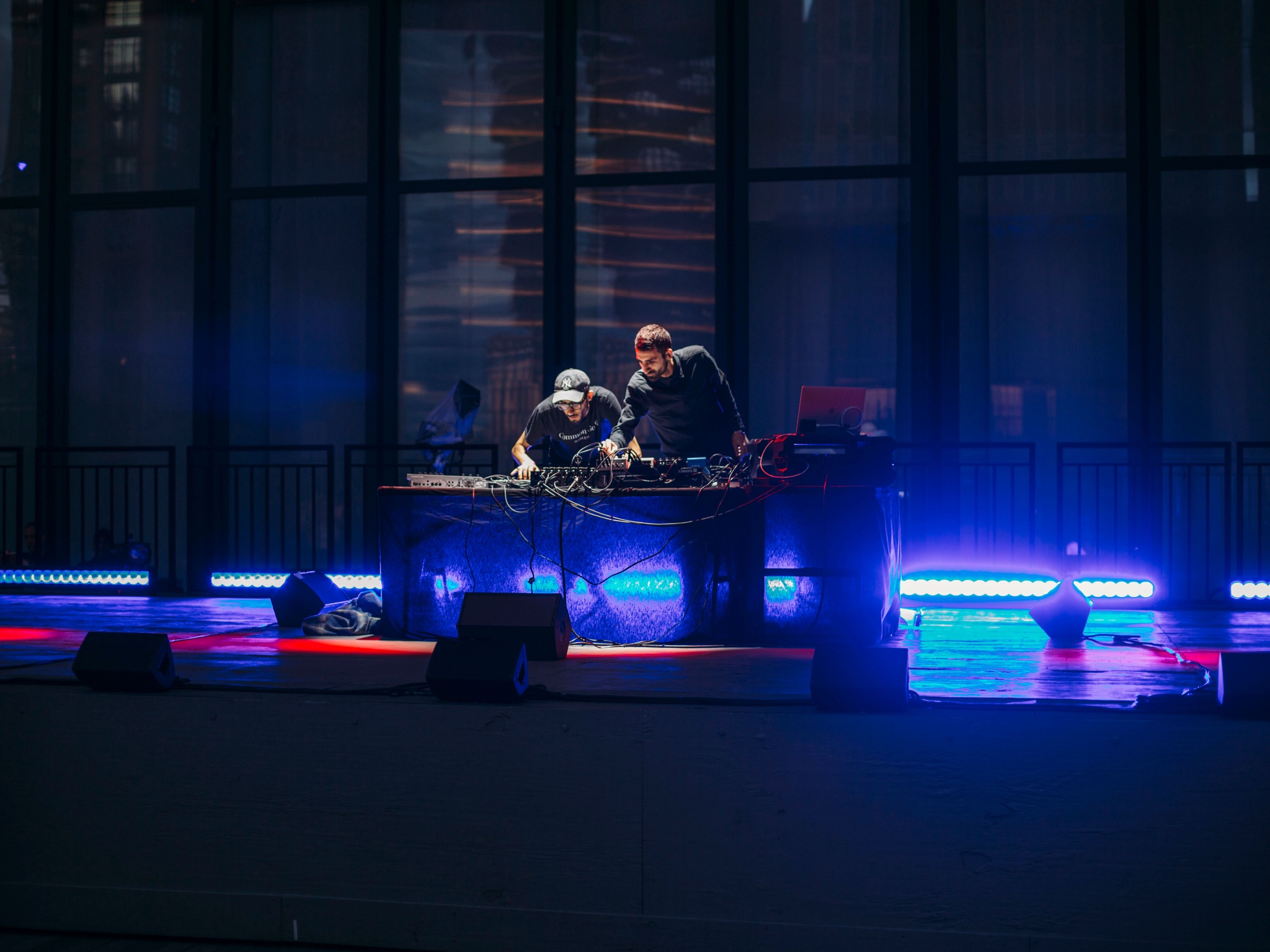 Two men behind an electronic DJ set up.