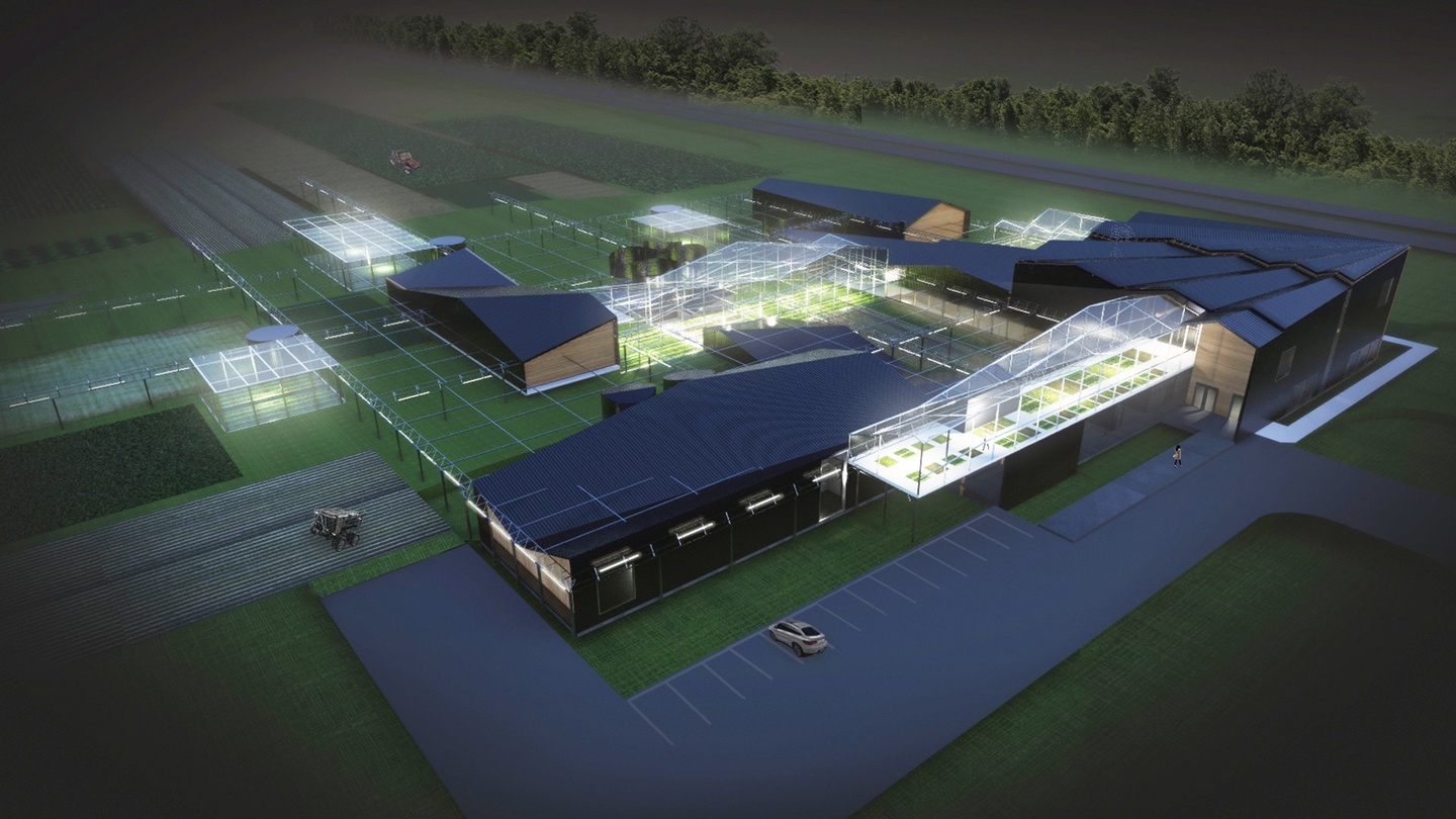 Computer rendering of an exterior night bird's eye view of large agricultural buildings in wood and black cladding, with glowing greenhouse spaces.