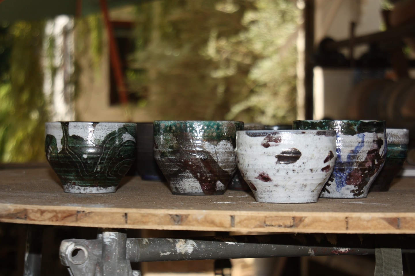 glazed raku pots sitting on a table 