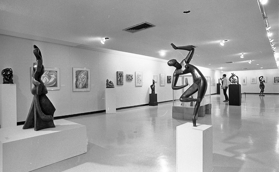 Gallery space with modern art sculptures and abstract paintings.