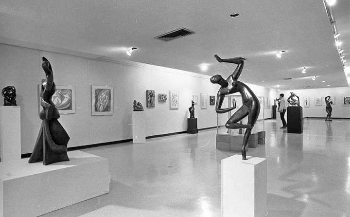 Gallery space with modern art sculptures and abstract paintings.