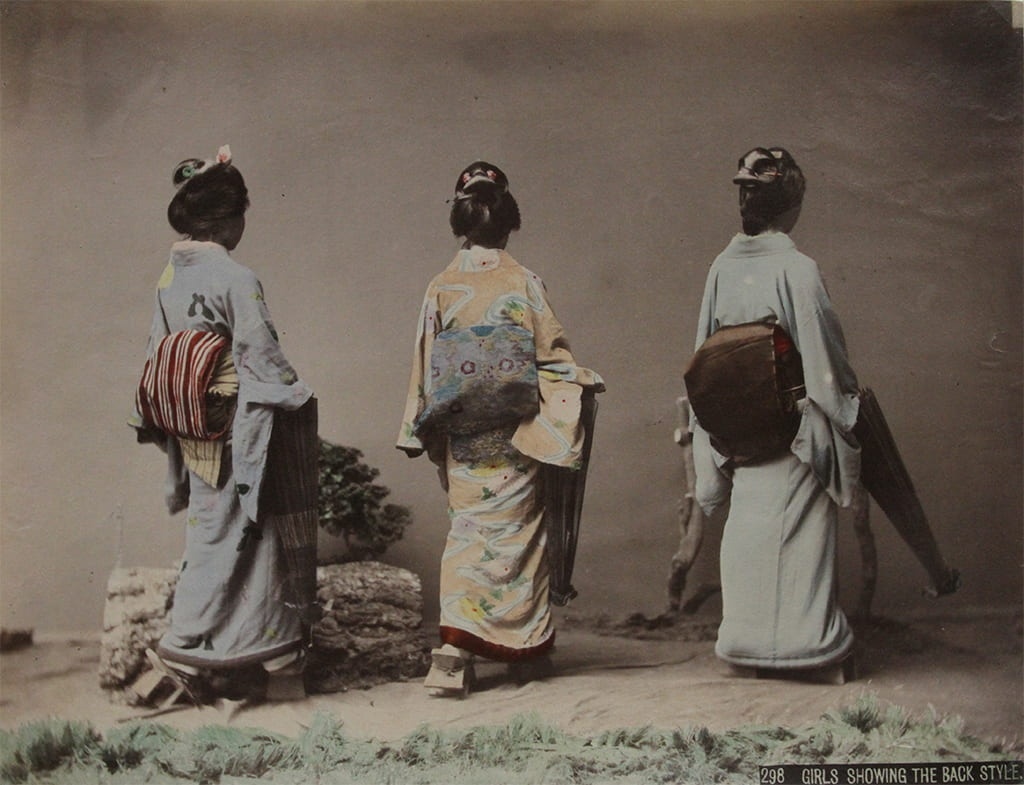 Three women in traditional Japanese dress standing with their backs to the camera