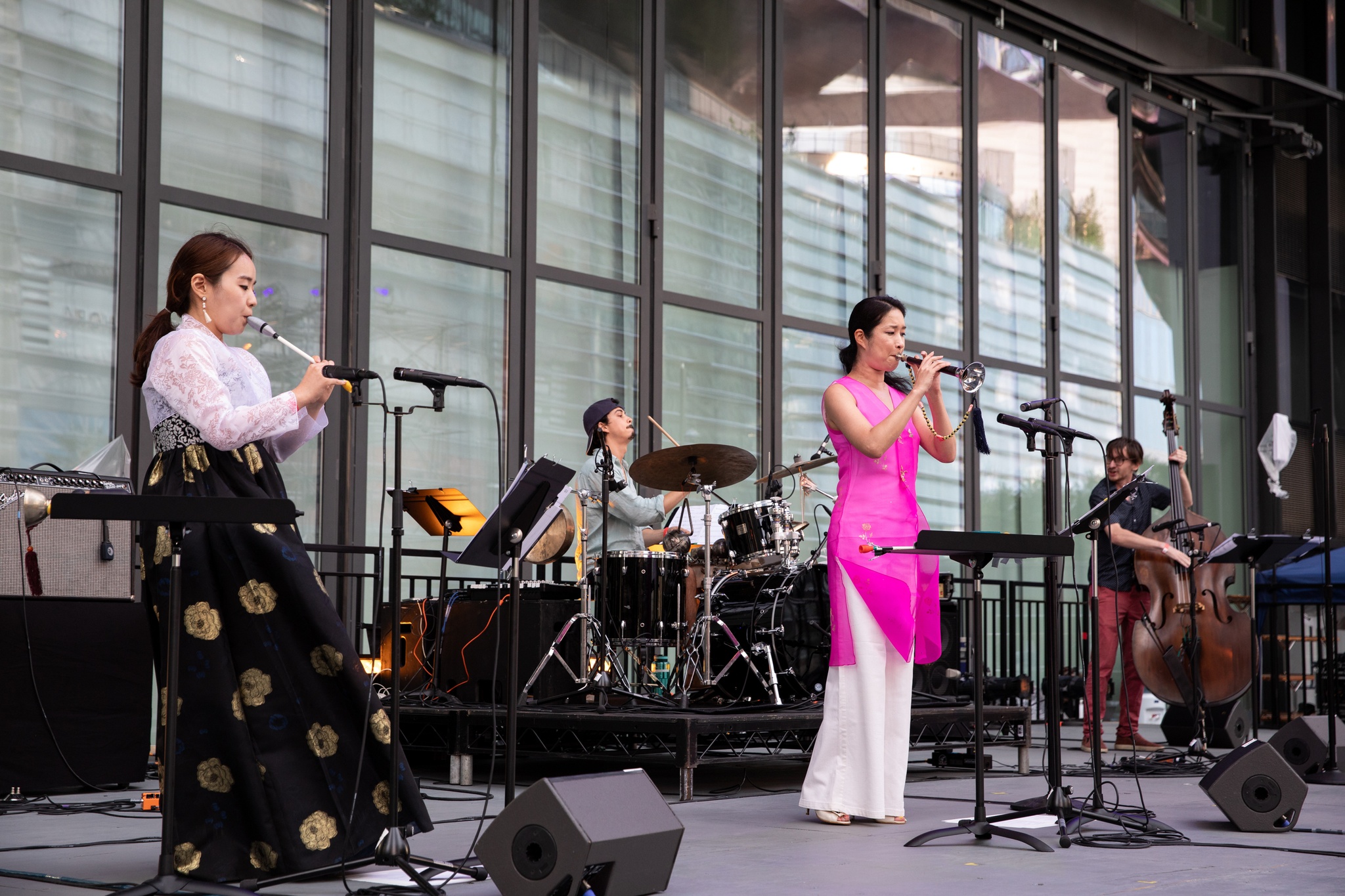 Women and men playing live instruments on a stage.