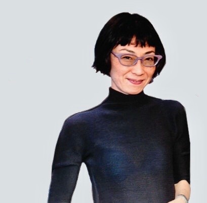 A portrait of Hitomi Iwasaki, an Asian woman with short hair cropped off just below her ears. She wears a navy blue tight turtleneck shirt and angular glasses. She smiles at us. 