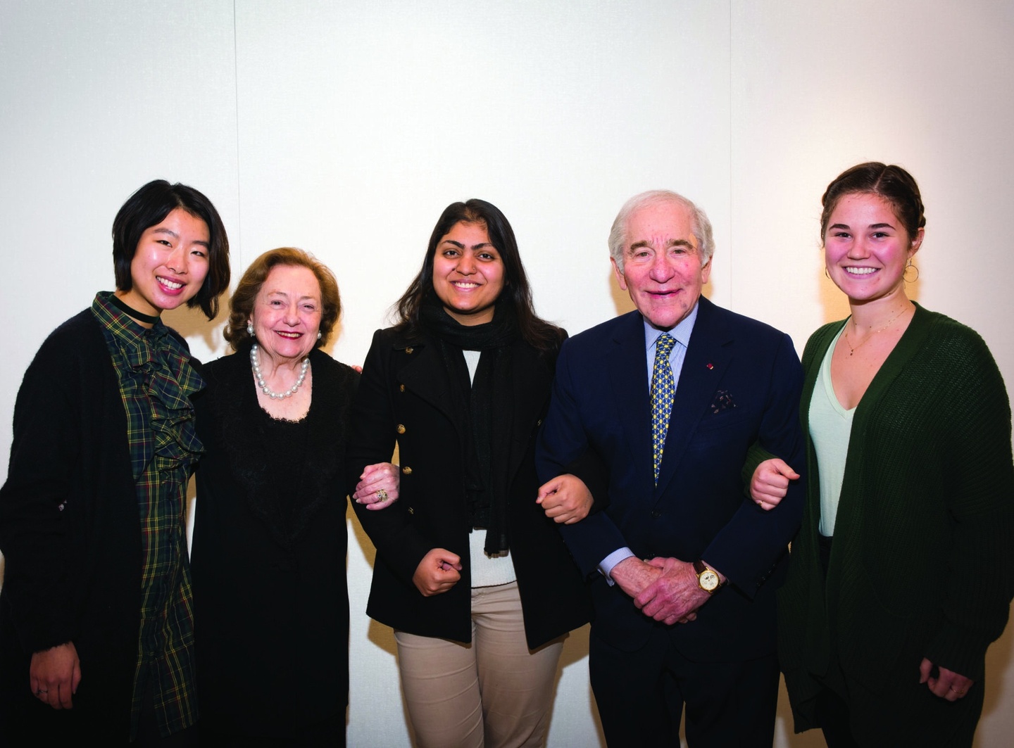 A group of five people dressed for a special event pose for a photograph.