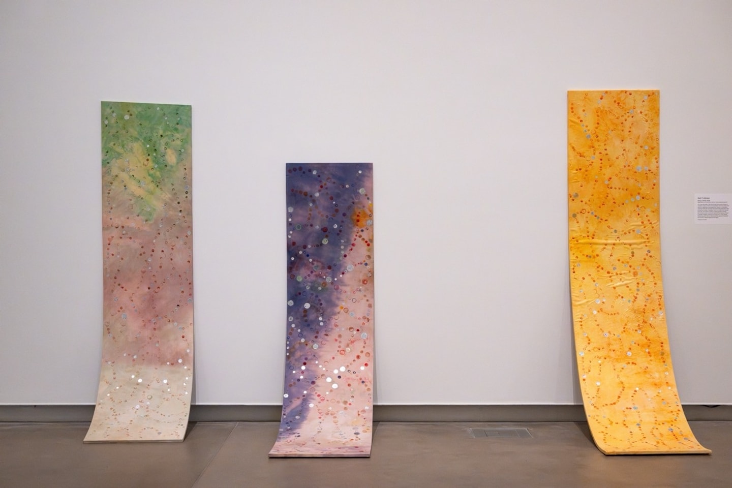 three boards covers in fabrics with yellows, pinks, green and silver leaf 