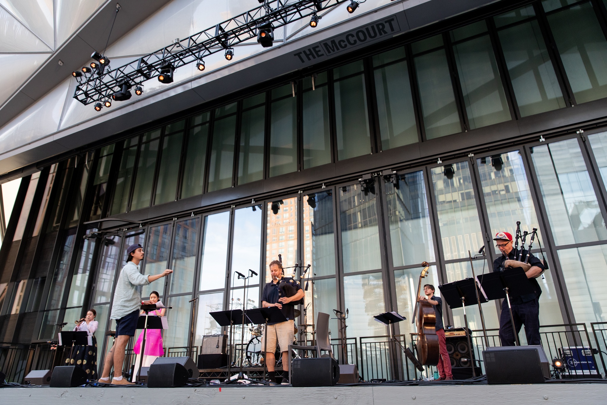 Women and men playing live instruments on a stage.