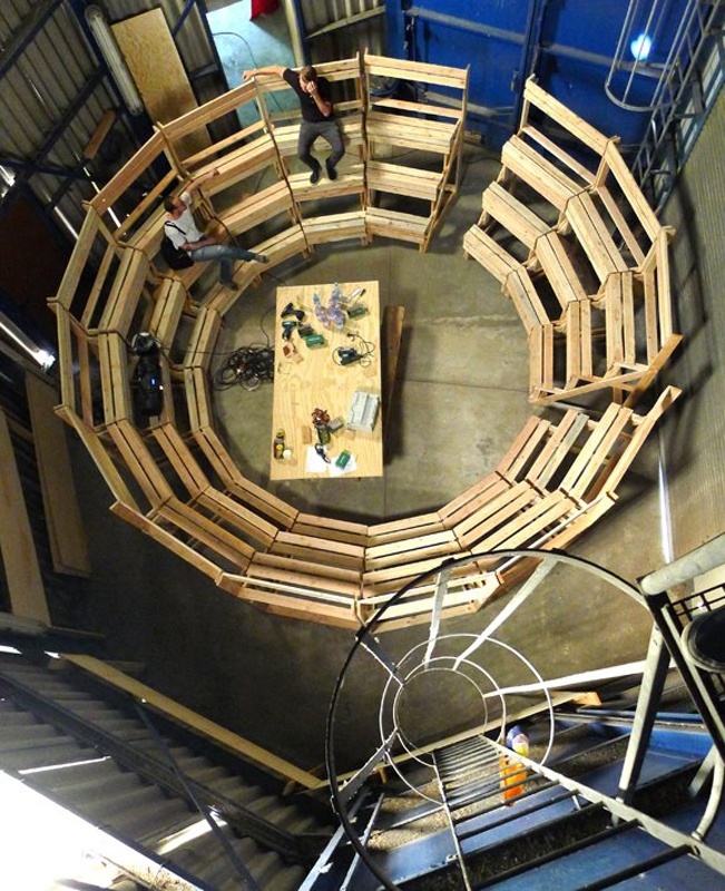 Aerial view of three-leveled tiered seating in a cylindrical pattern made of wood