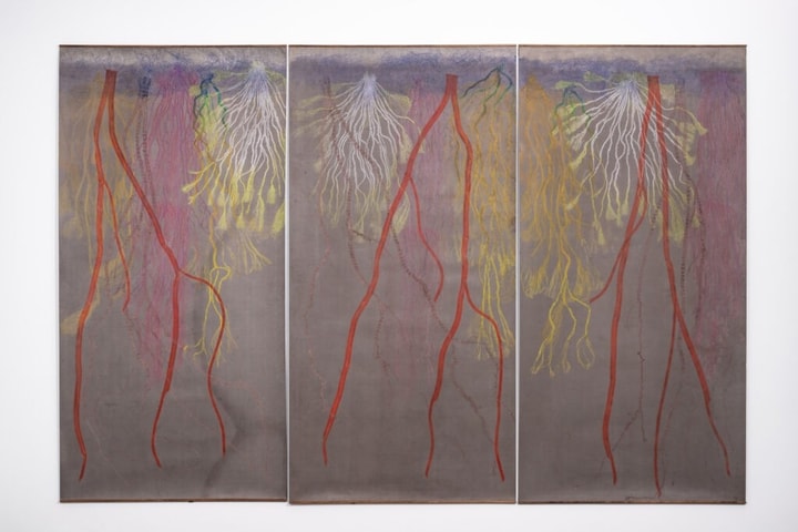 triptych of roots printed in reds, yellows, and oranges