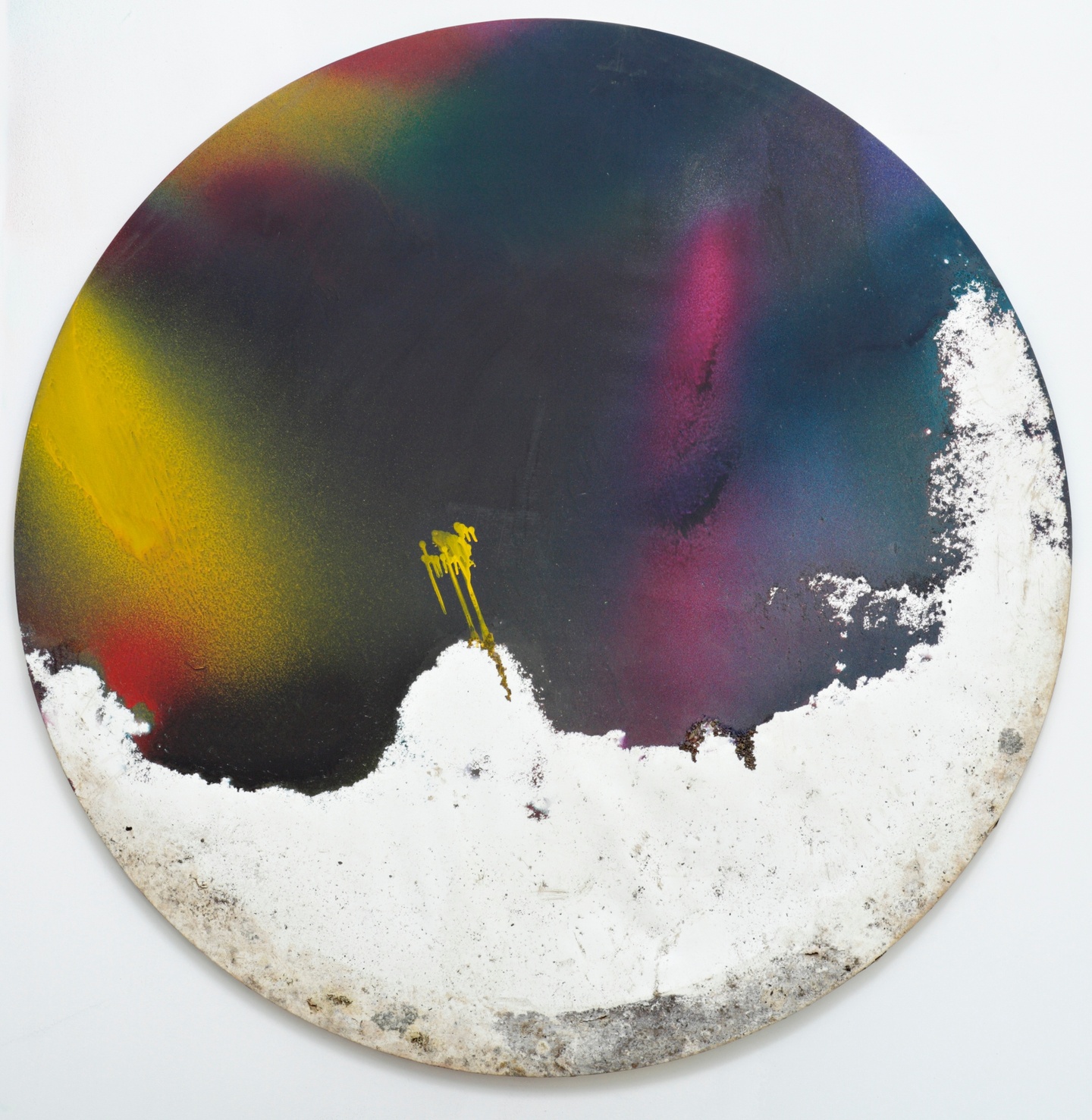 A circular abstract paintings with vibrant blue, gold, and yellow sprays of color above an unfinished and damaged section of canvas at the bottom