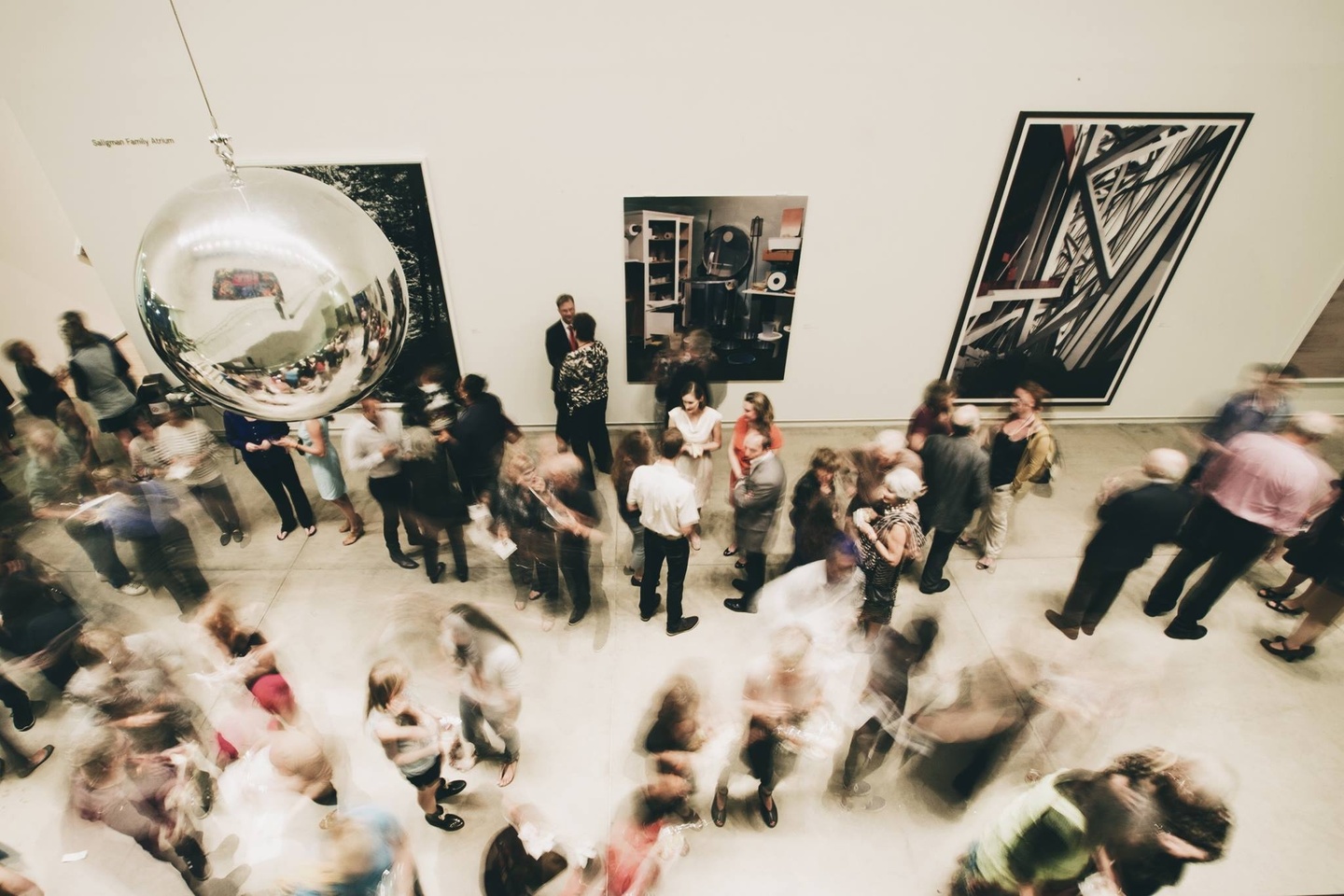 A crowd of people at a reception inside a museum space