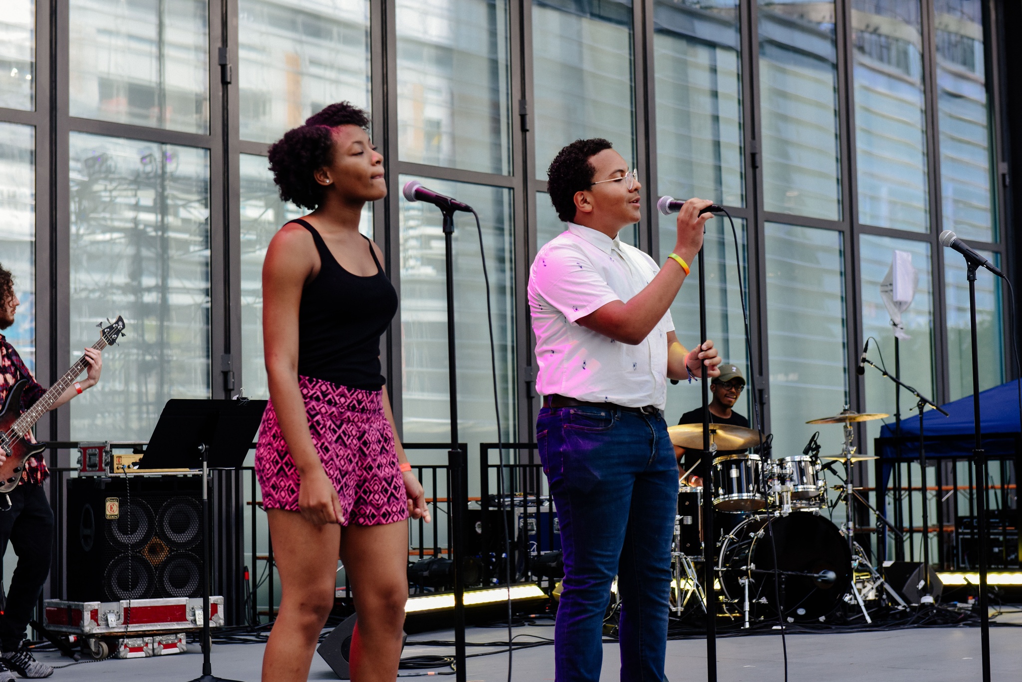 Singer singing on outdoor stage.