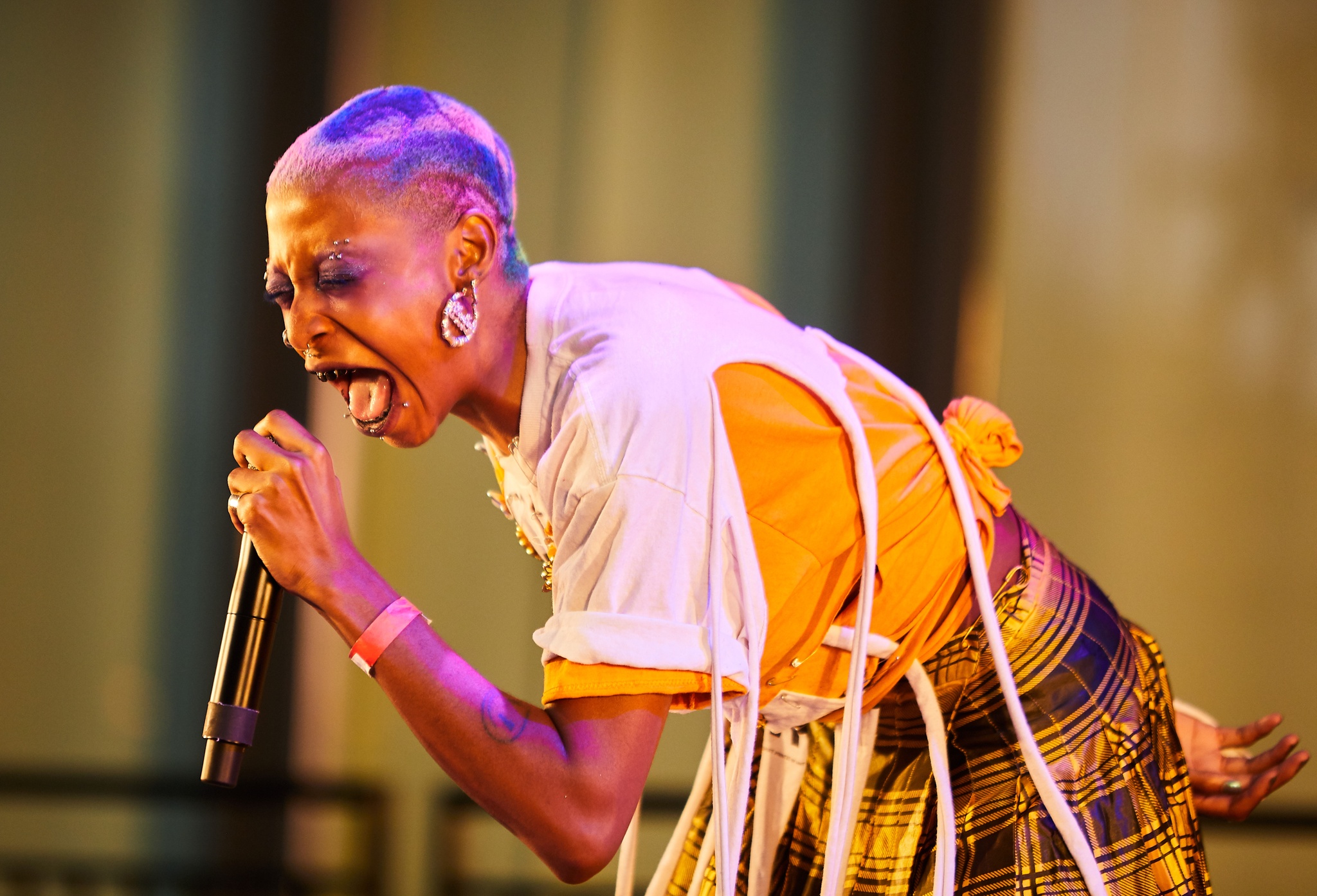 Singer singing into mic on dramatically lit stage.