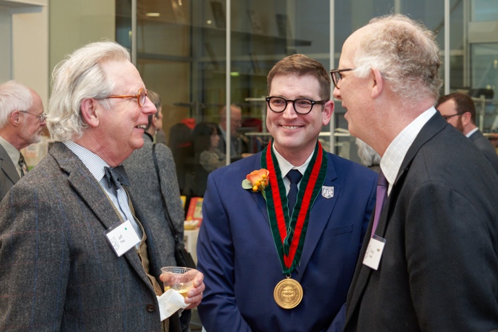 Three men talking with each other.