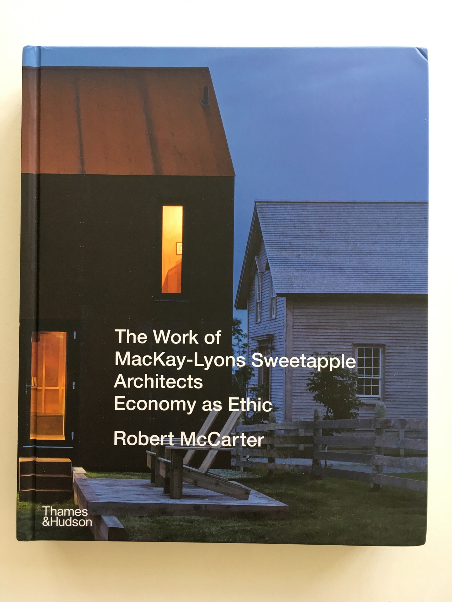 Cover of The Work of MacKay-Lyons Sweetapple Architects: Economy as Ethic, featuring a photo of two homes at dusk.