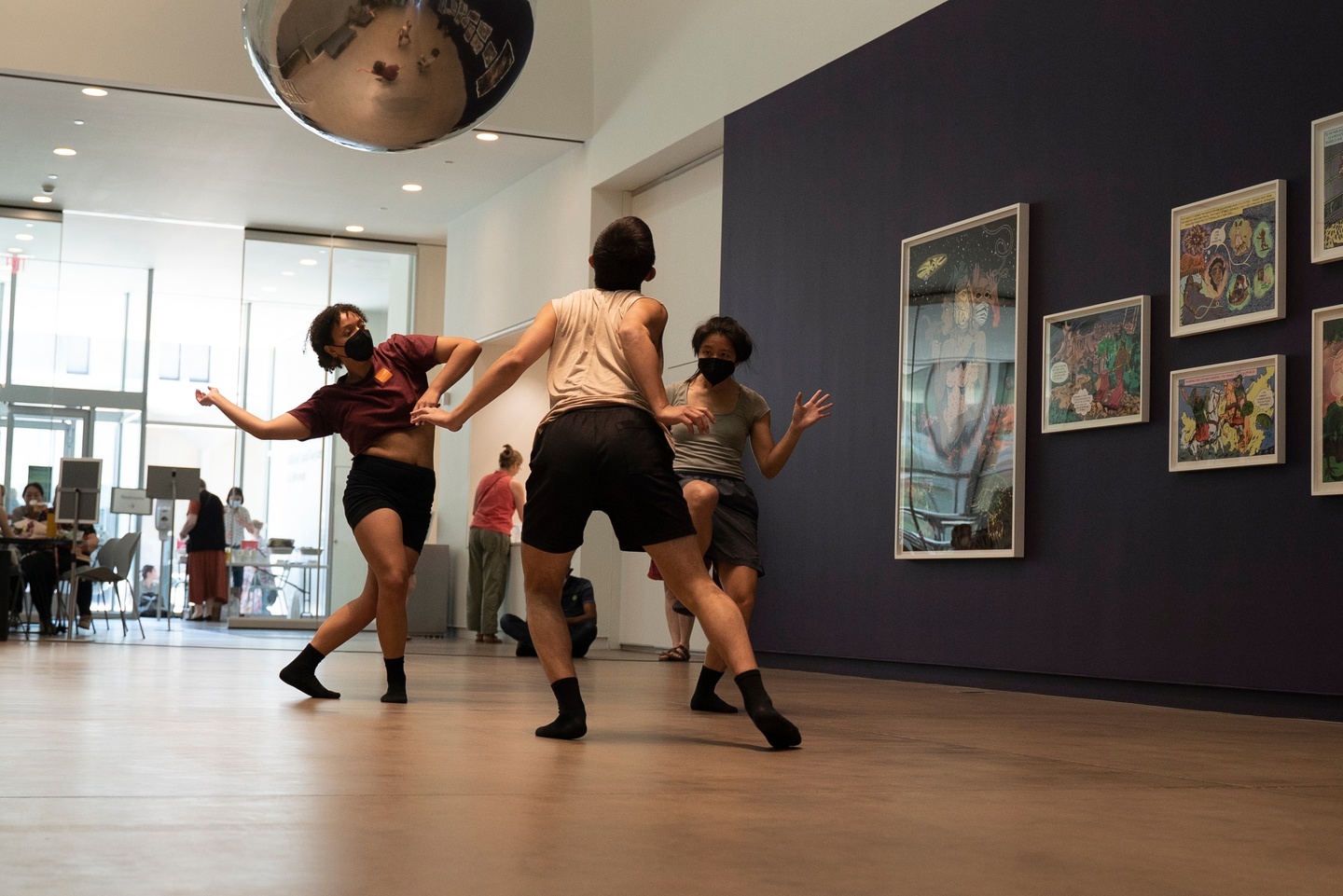 Three people dancing in a museum space