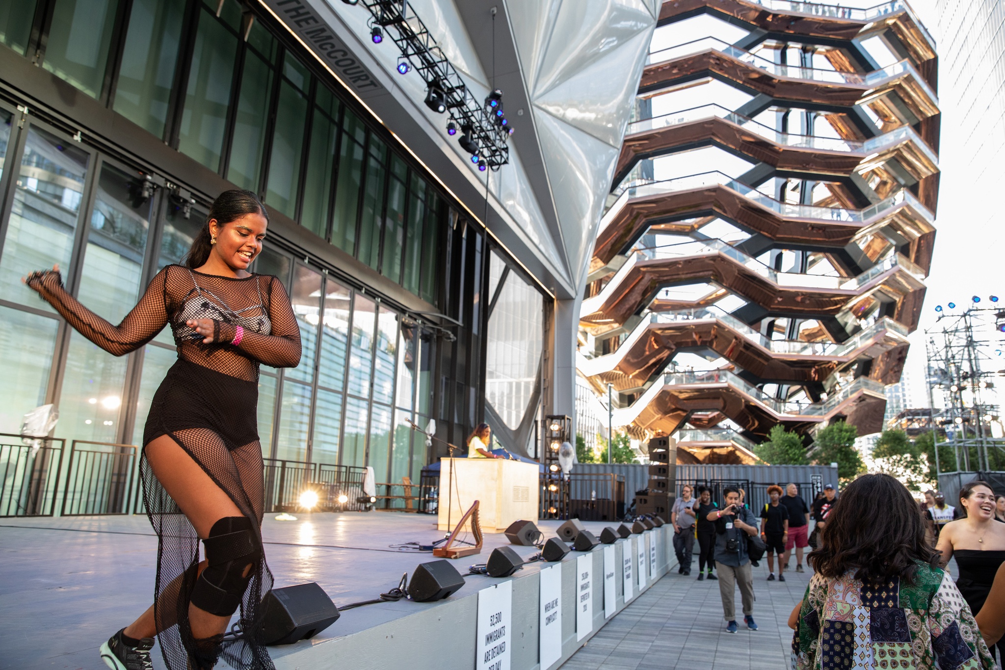 Dancer and DJ performing on outdoor stage.