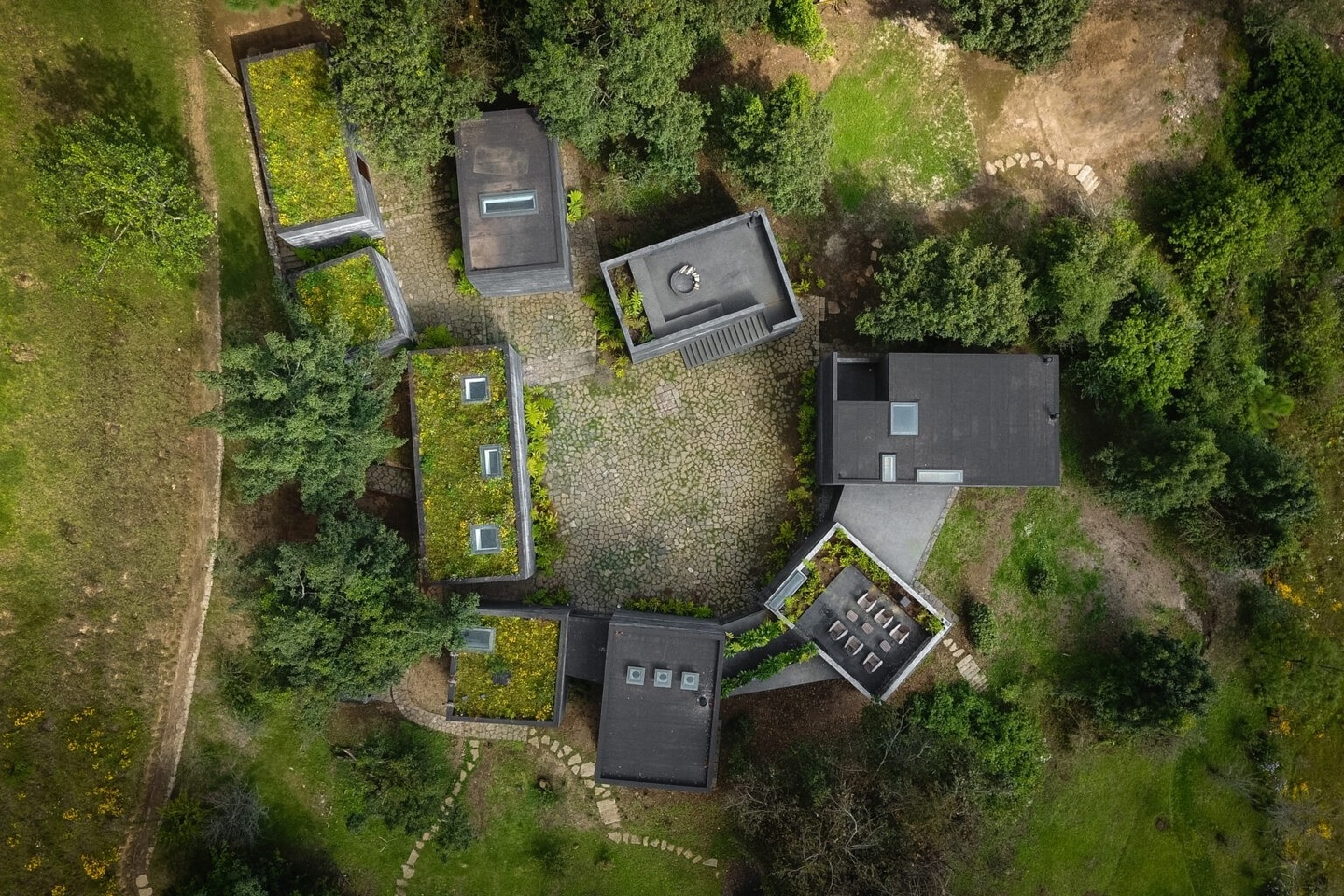 bird's eye view of Casa Bruma, the top of several buildings set among green trees and land 