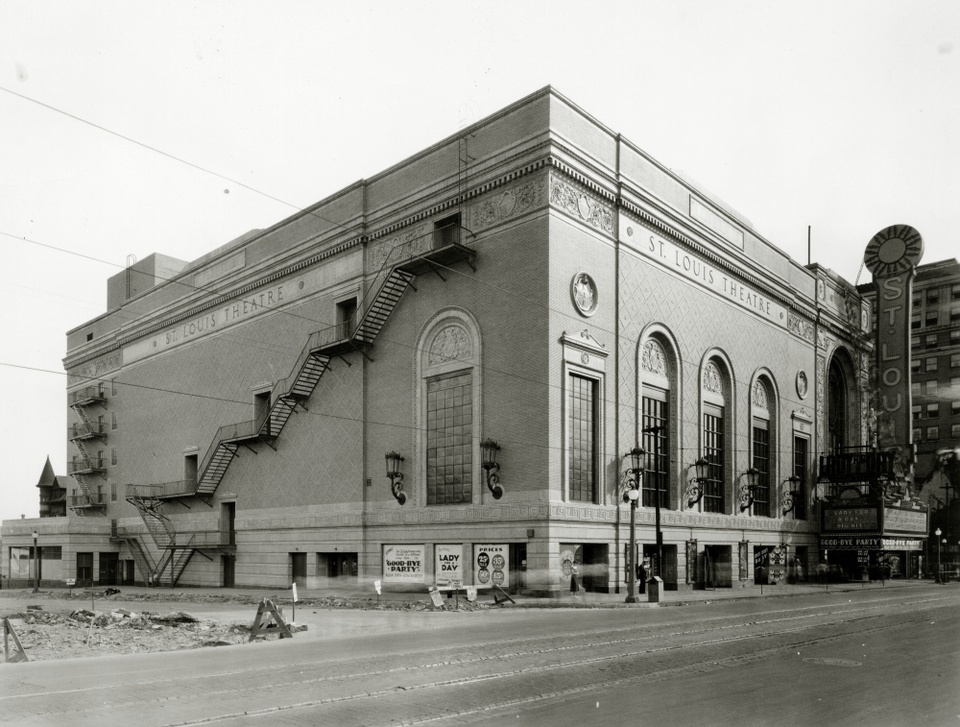 Black-and-white exterior photo of a multi-story theatre building with a stair-step pattern of stairs along the far left exterior.
