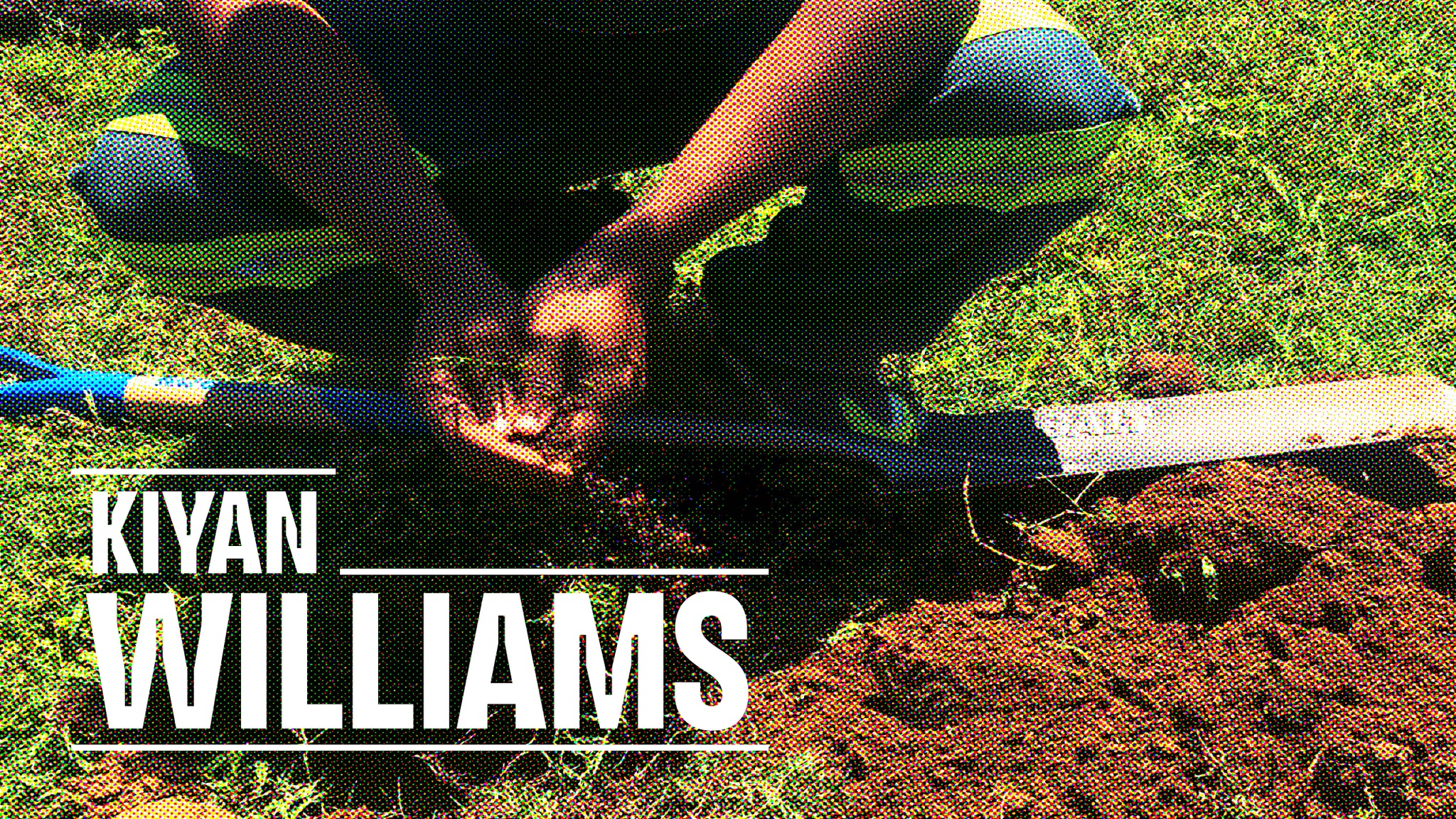 A person crouches on green grass over a shovel and upturned earth with their hands joined together with the name Kiyan Williams overlaid in white text