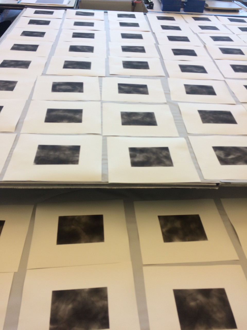 Rectangular sooted prints laid out across the tables for drying