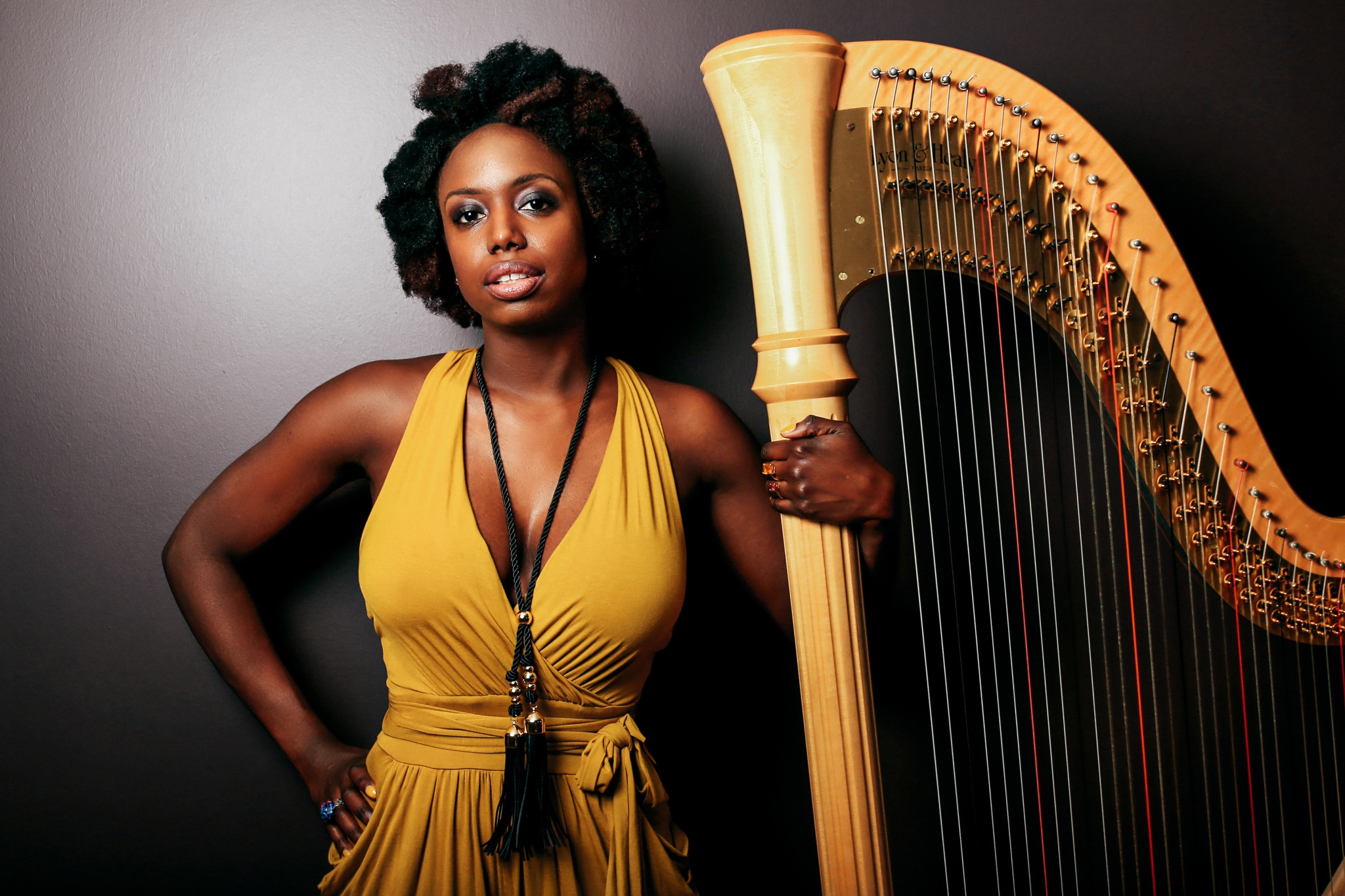 A portrait of Soundtrack of America artist Brandee Younger posing with a harp