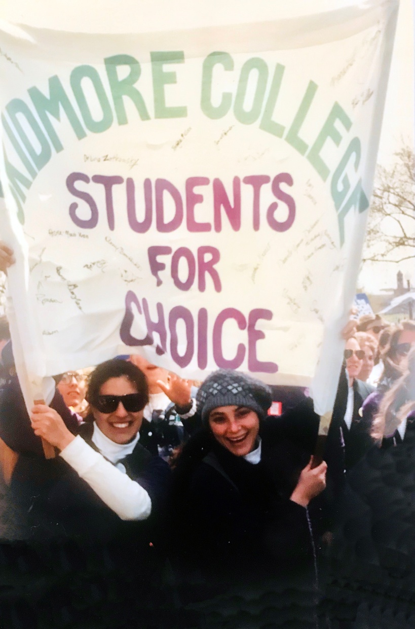 A color photograph shows a crowd of people with two smiling light-skinned women holding a large white banner emblazoned with the words SKIDMORE COLLEGE STUDENTS FOR CHOICE.”