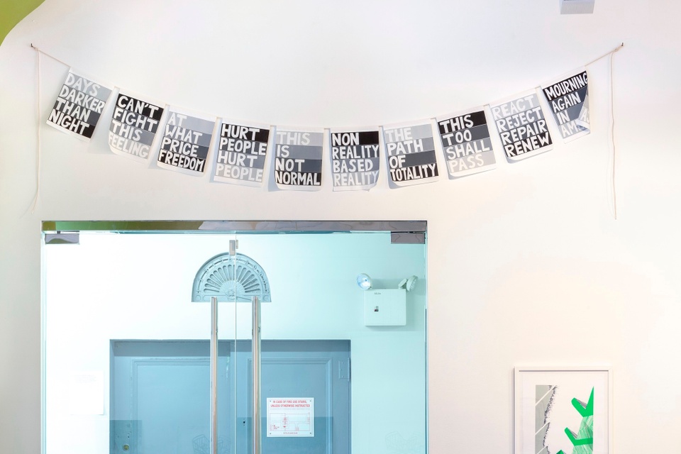 A room with a doorway and the string of bunting made by Lisa Anne Auerbach hanging above.