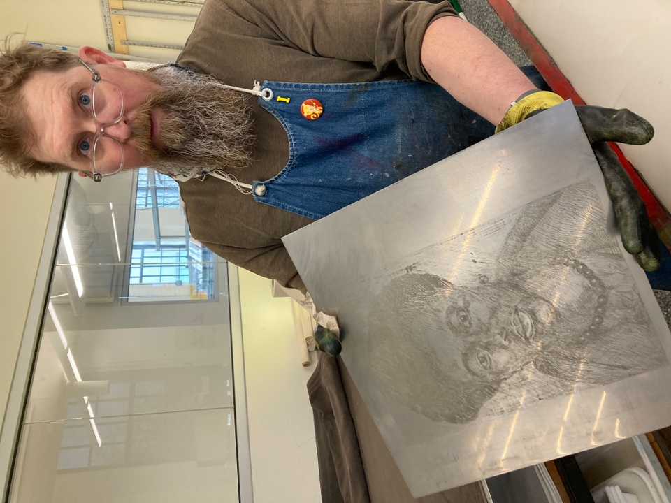 Printer Tom Reed holding etching plate with drawing of woman made by artist Meleko Mokgosi