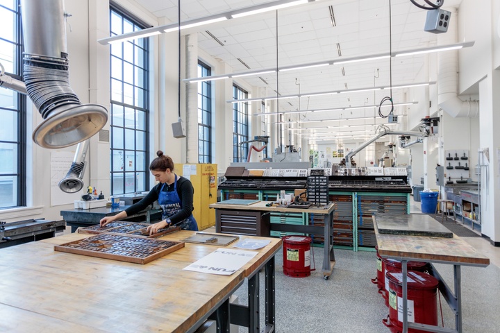 Wide angle shot of a high-ceilinged printmaking and letterpress studio.