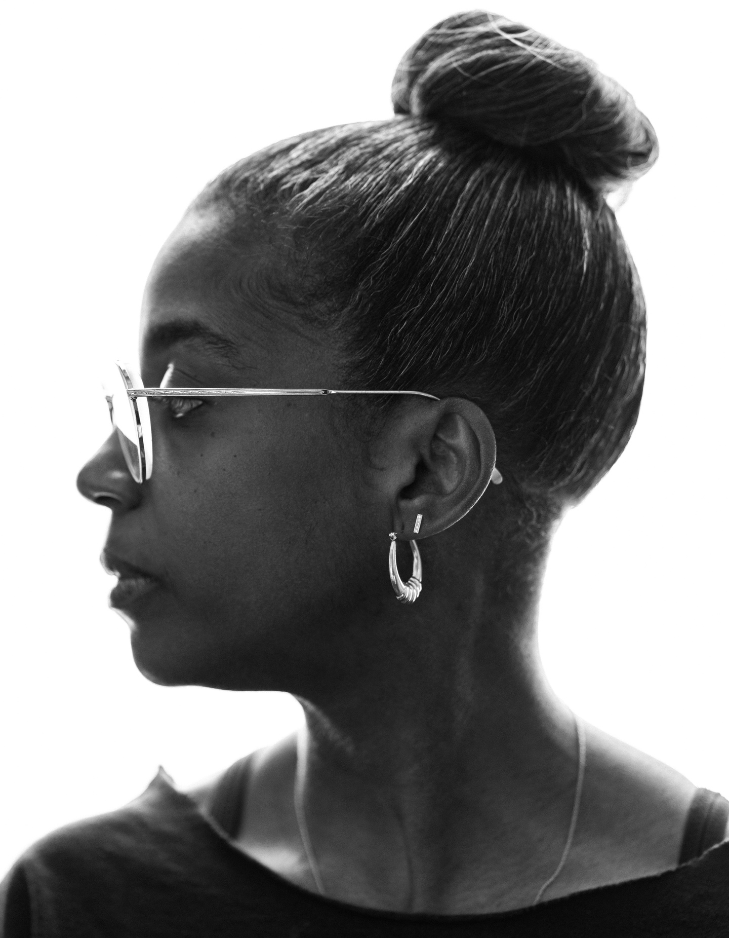 Black-and-white profile photograph of Simone White wearing glasses and with her hair in a bun 