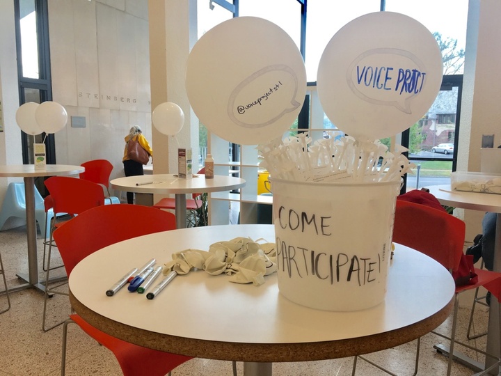 Two balloons in a bucket that says "Come Participate!"