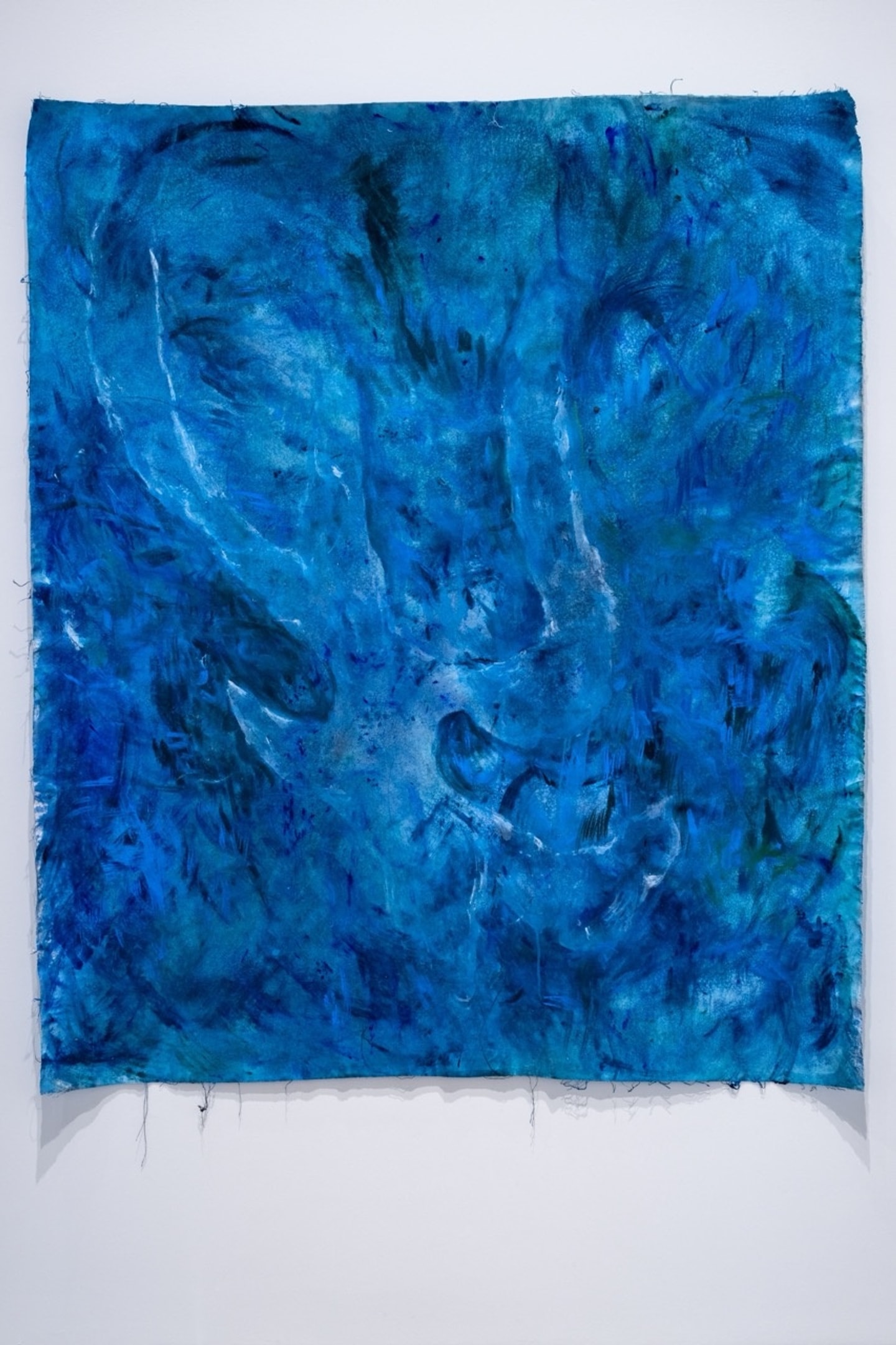 shades of blue paint and ink swirled on a canvas