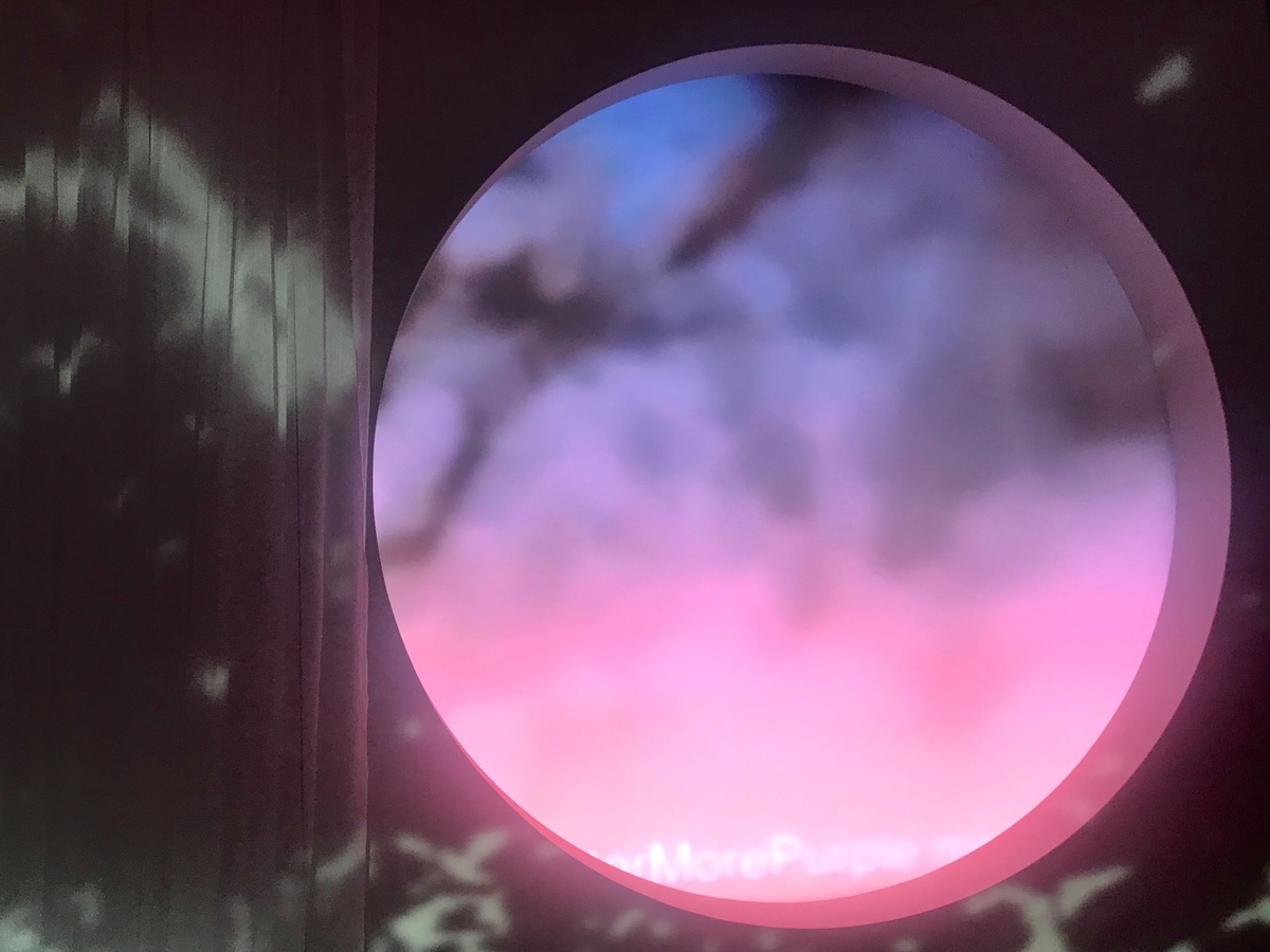 Circular "window" looking out at an animated blue and pink sky