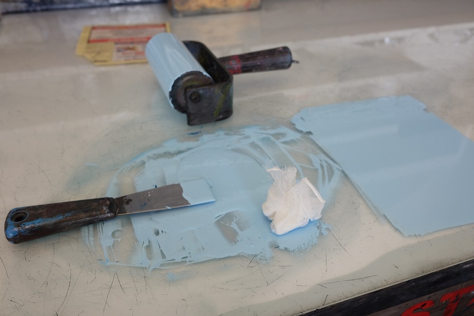 light blue inked rolled out on glass slab in print shop