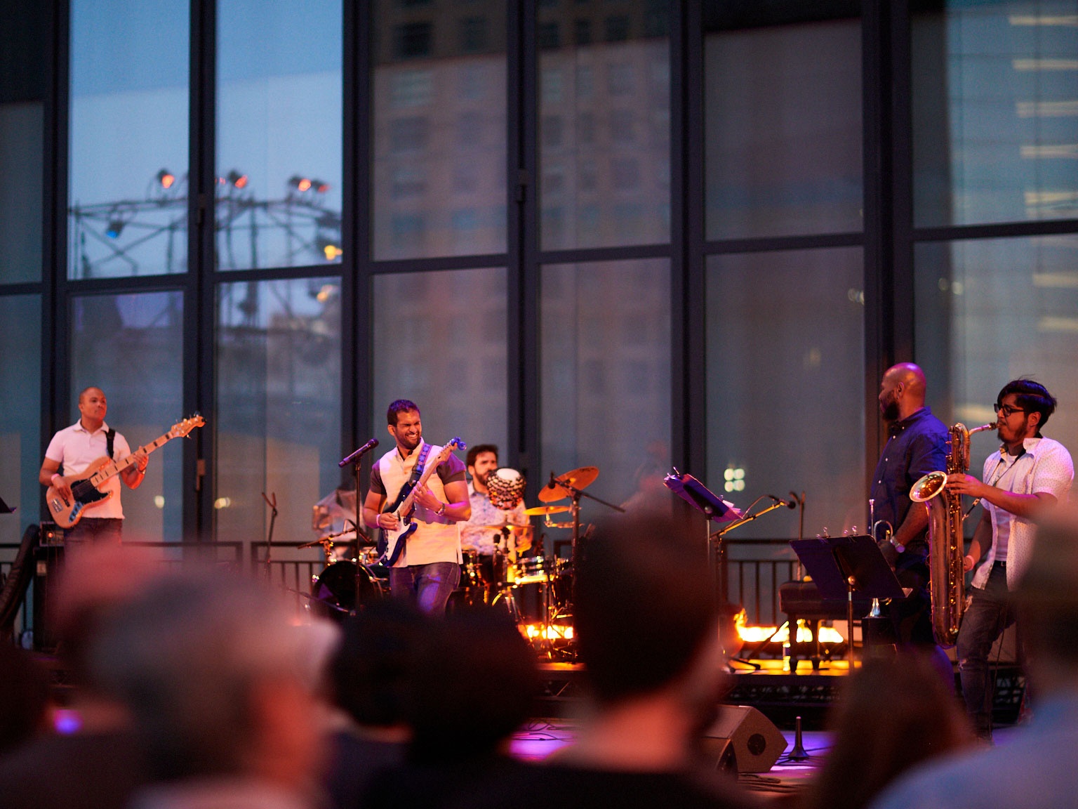 Men playing live instruments on a stage.