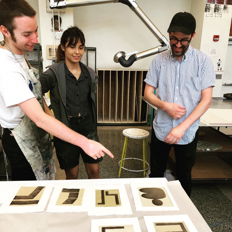 Interns and artist looking at proofs of prints just printed.