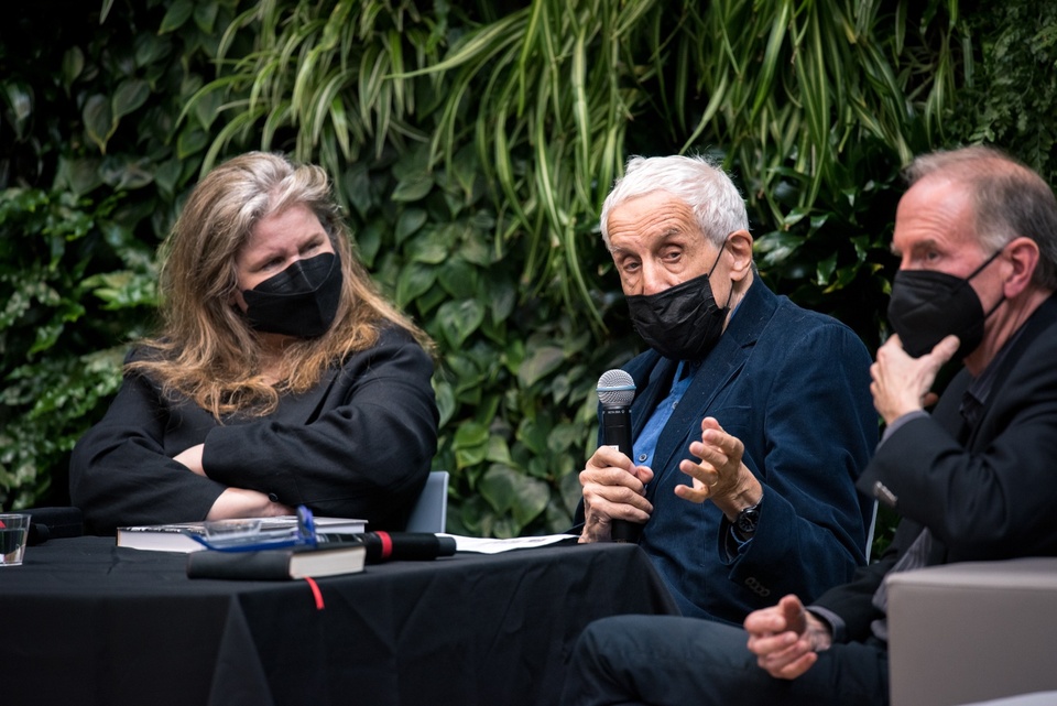 Close up of three panelists at a table speaking into a microphone.