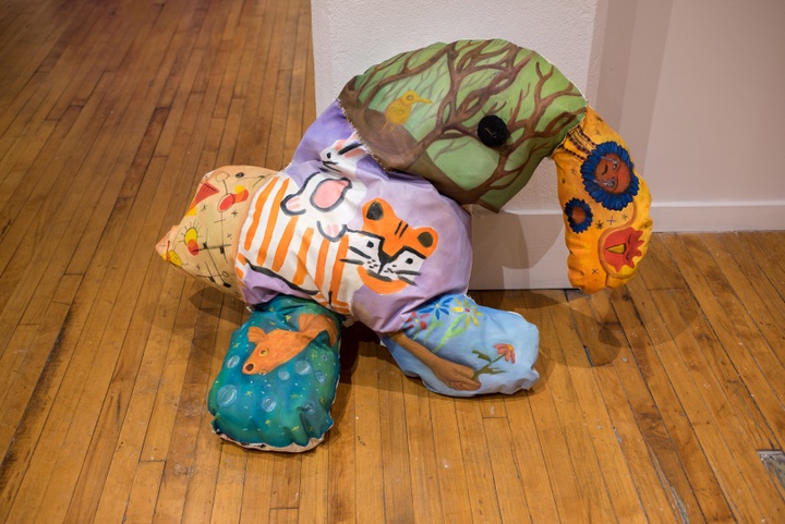 Stuffed fabric object with several sections and protrusions with different, colorful, cute paintings of animals on them.