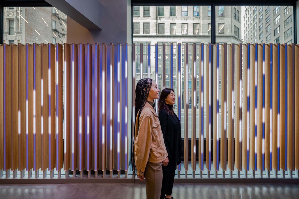 Two visitors of the sales center from profile view with vertical fins behind them, displaying "49%" in large text