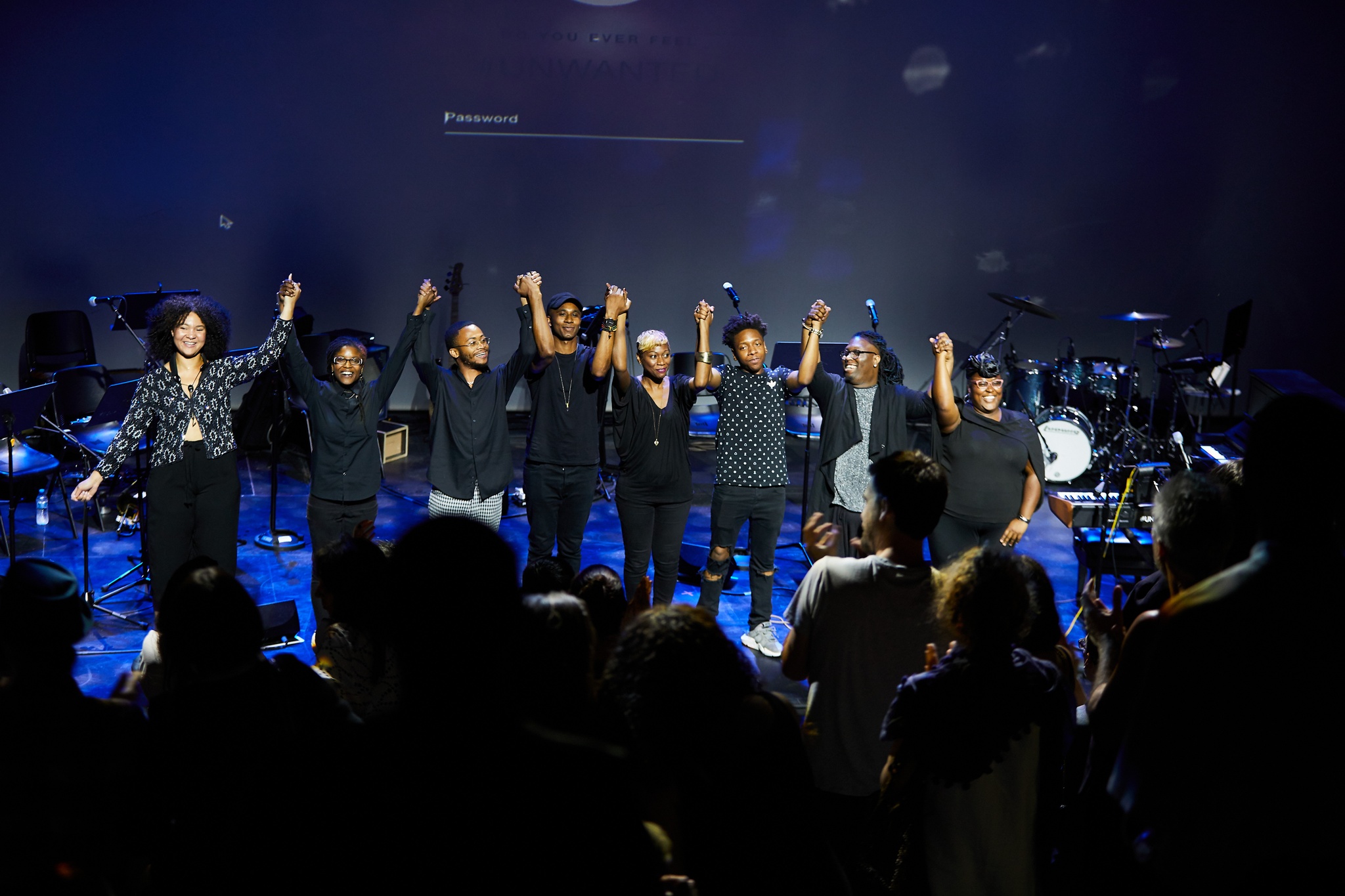 Performers taking a bow on stage to standing ovation.