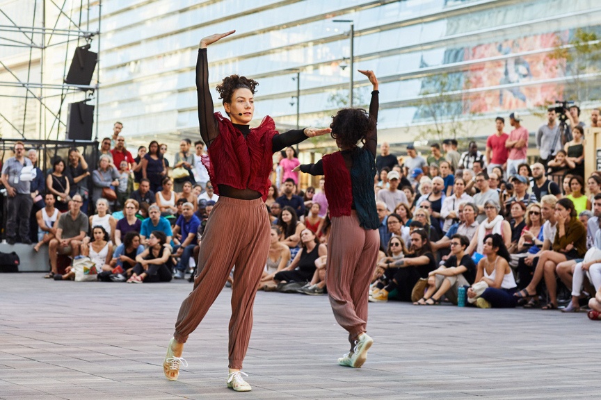 Two dancers in motion on an outdoor stage.