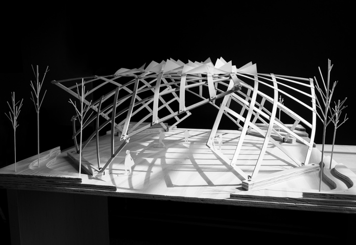 Black-and-white photo of an architectural model, featuring a gridded building shell, dome-like in shape, with some triangular points at the top.