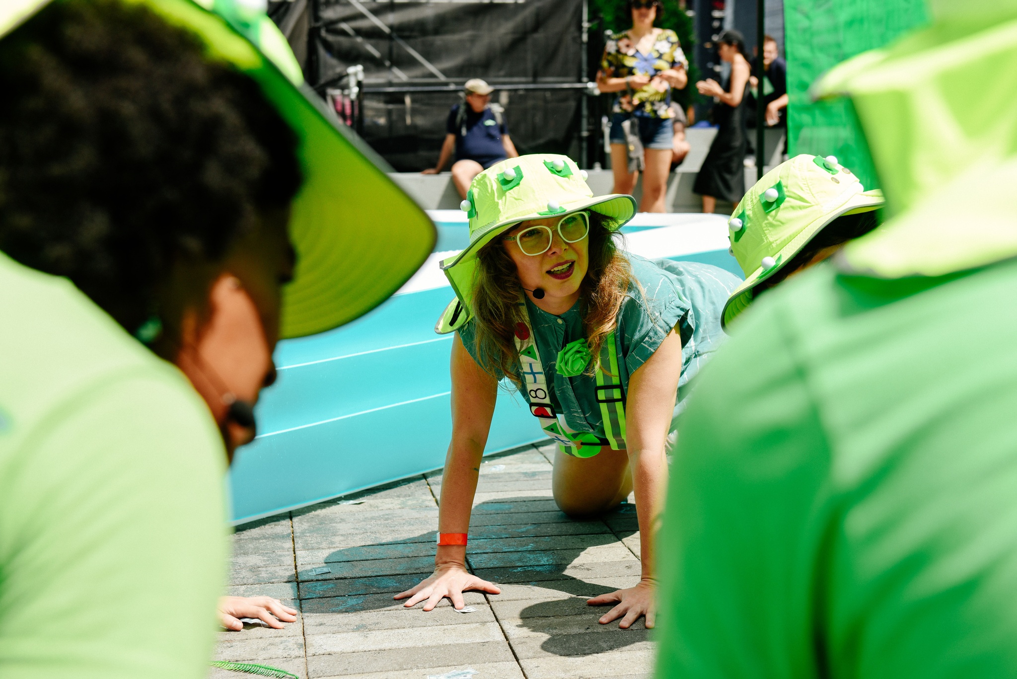 A group of participants in green hats around a kiddie pool.