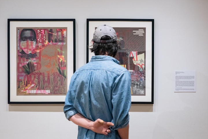 Person looks at two framed collage works in a gallery.